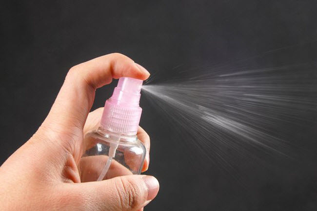 A person spraying homemade mosquito repellent around the room